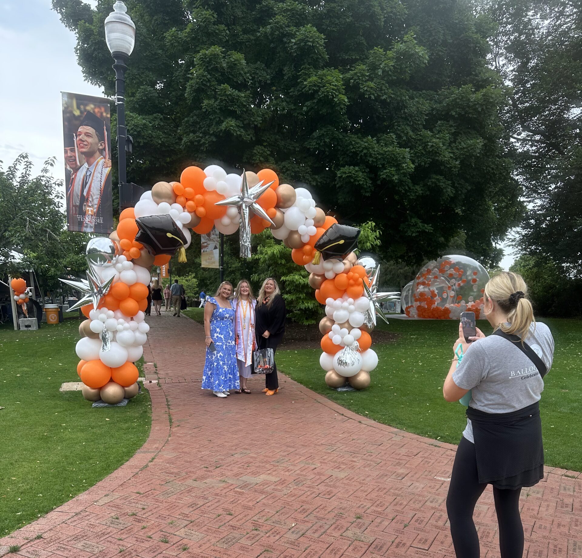 University of Tennessee Graduation Balloon Garland featuring Graduation Cap Balloons, Chrome Spiked Balloons, Gold, White, Chrome, Orange Balloon Arch